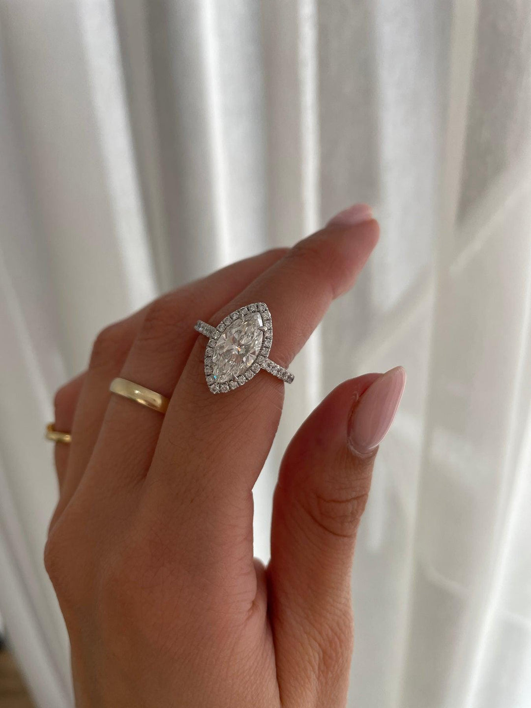 a woman's hand holding a diamond ring