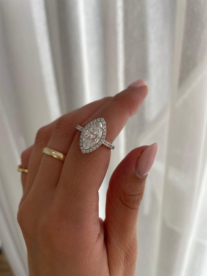 a woman's hand holding a diamond ring