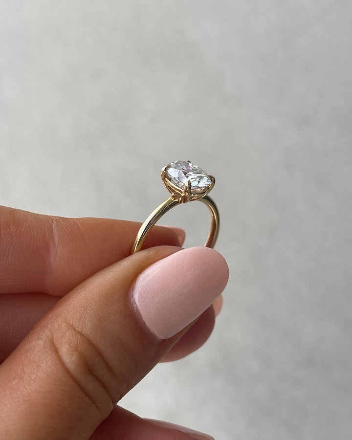 a woman's hand holding a diamond ring