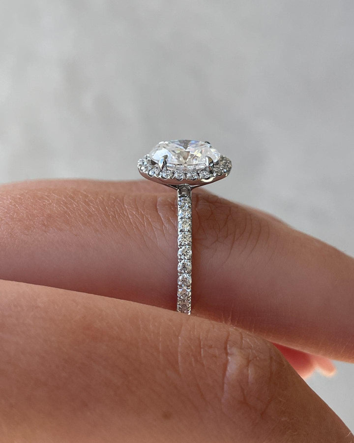 a close up of a person's hand holding a diamond ring
