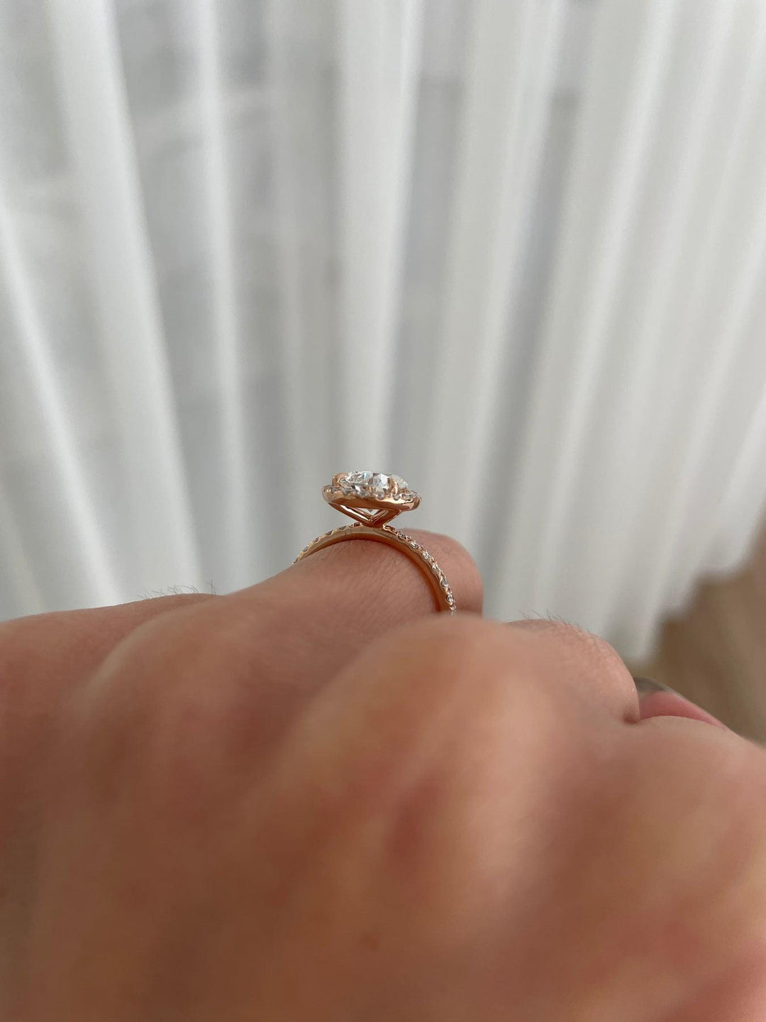 a close up of a person's hand holding a diamond ring