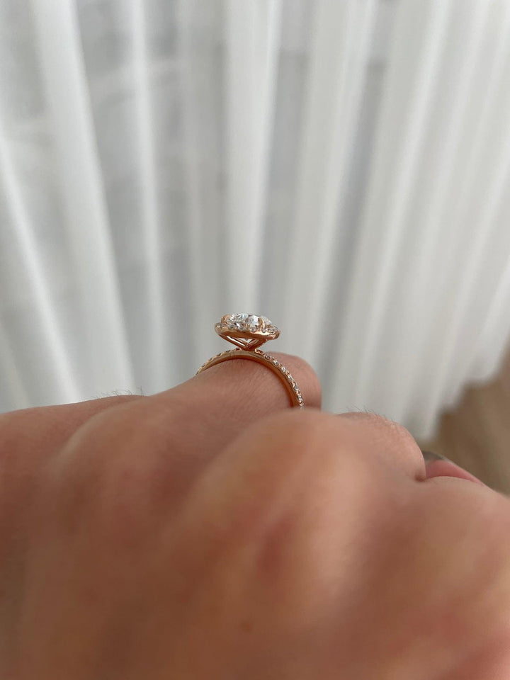 a close up of a person's hand holding a diamond ring