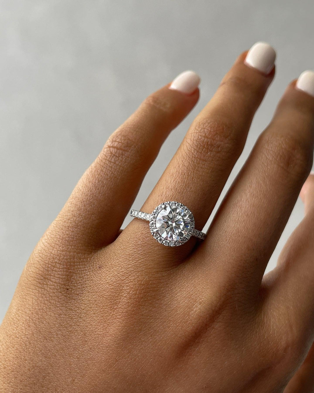 a woman's hand with a diamond ring on it