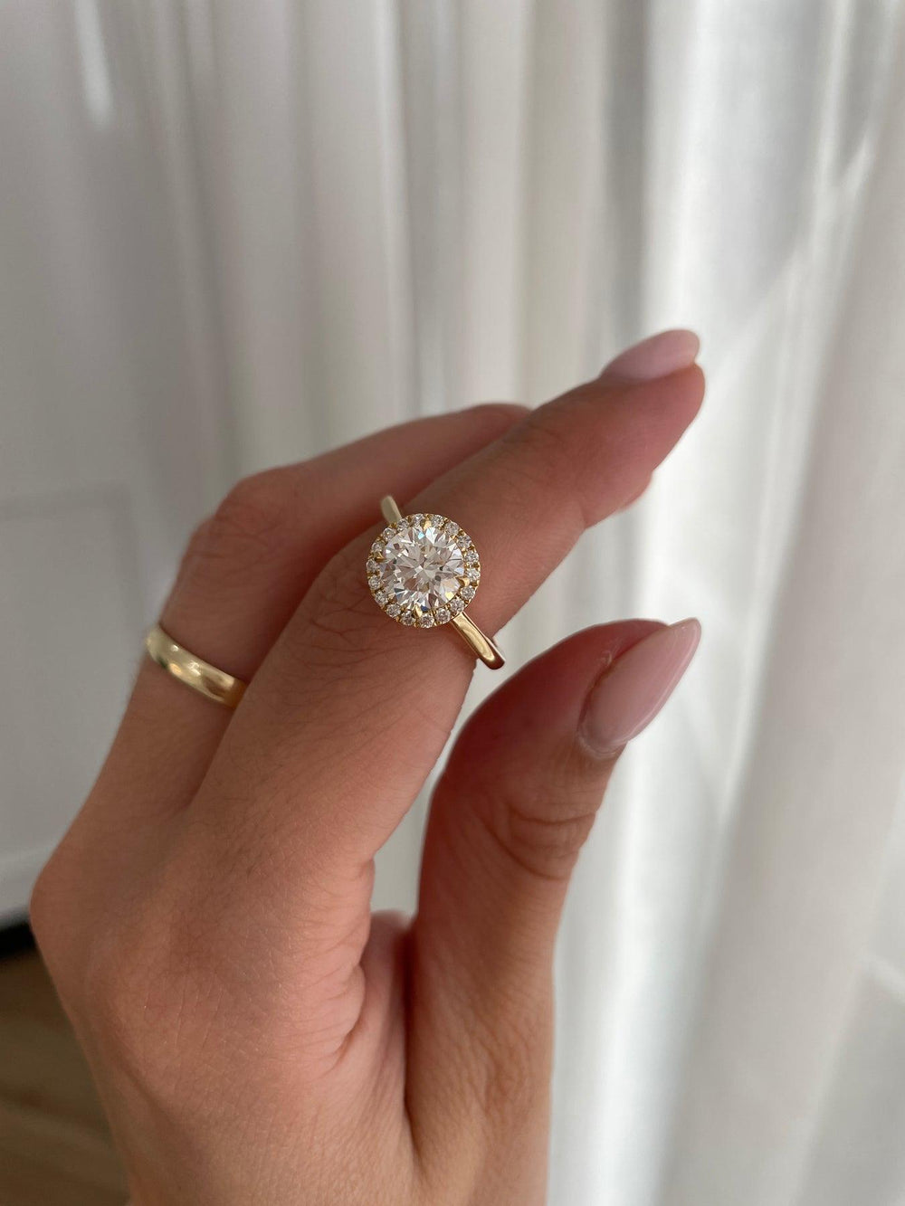 a woman's hand holding a diamond ring