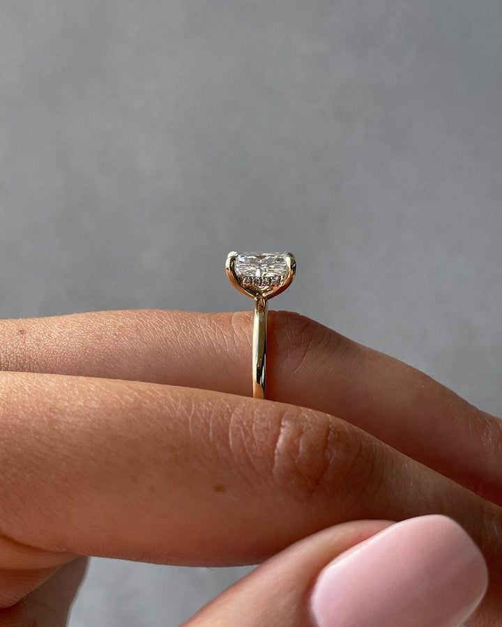 a close up of a person's hand holding a diamond ring