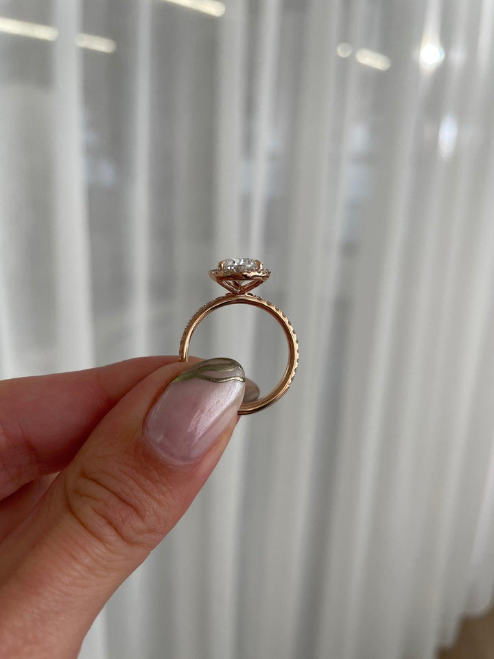 a person holding a ring with a diamond on it
