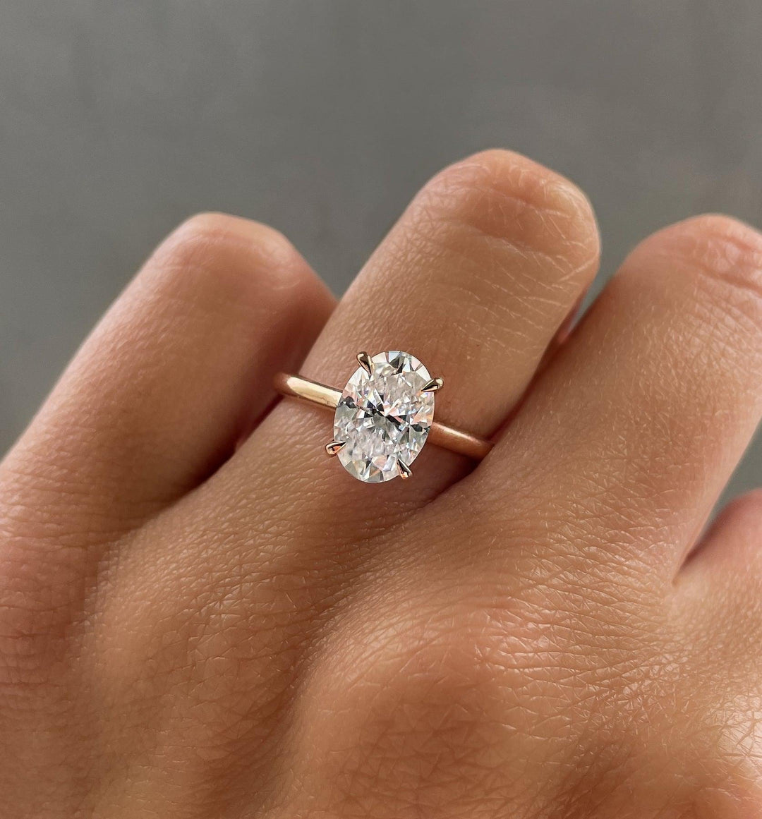 a close up of a person's hand with a diamond ring