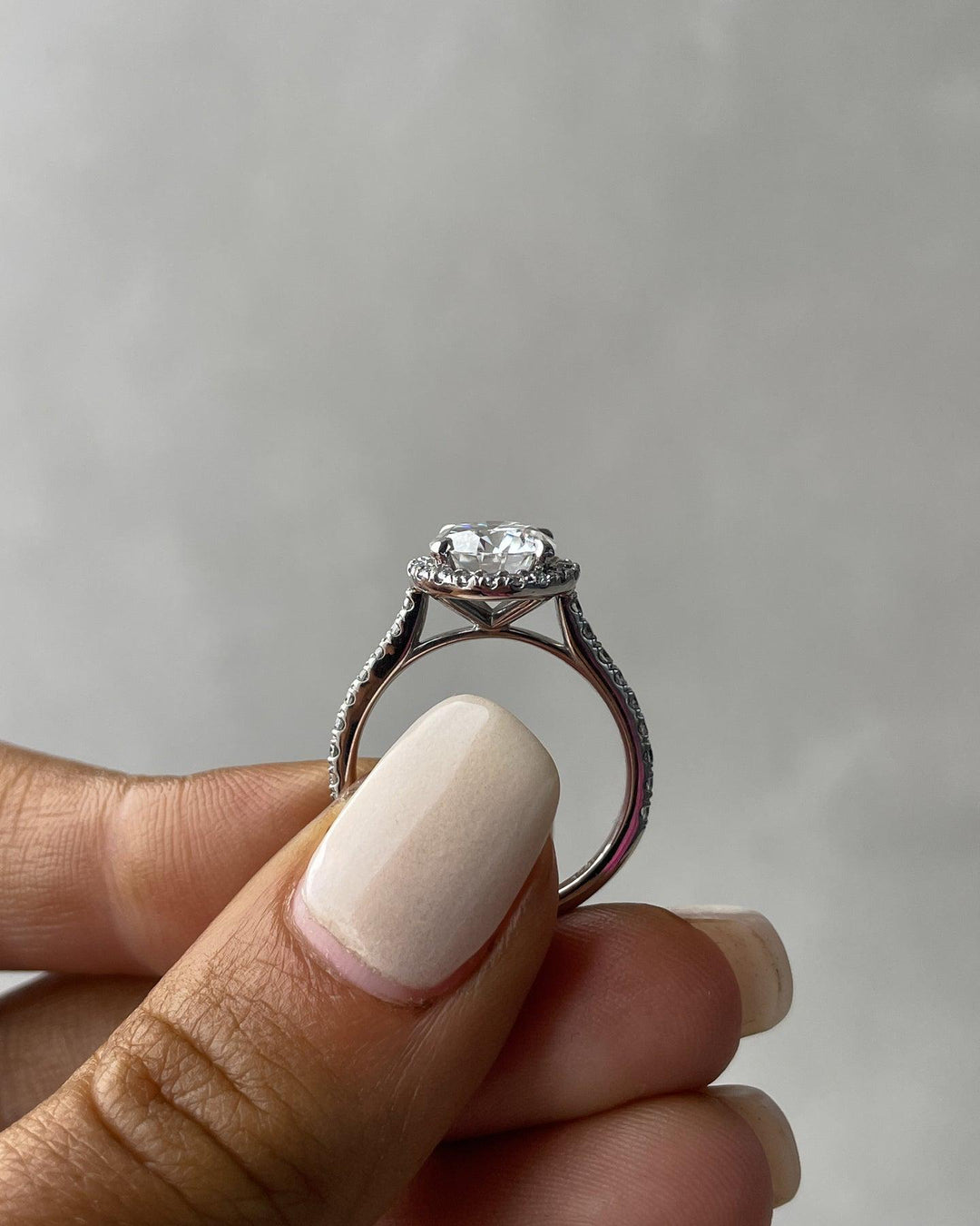 a woman's hand holding a diamond ring