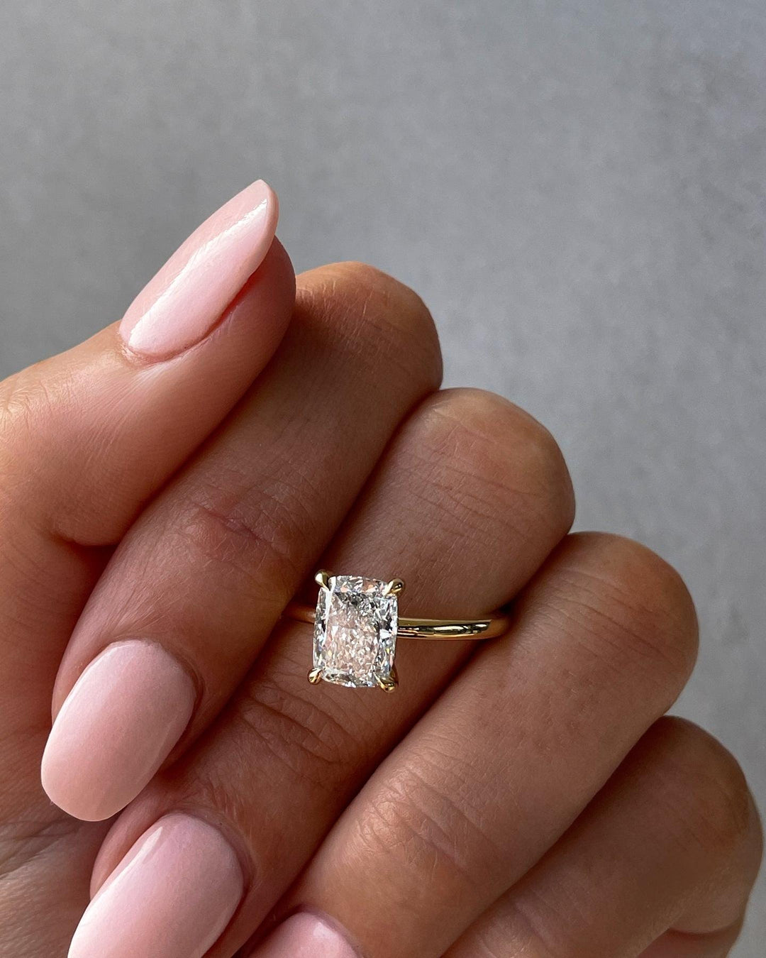 a woman's hand holding a diamond ring