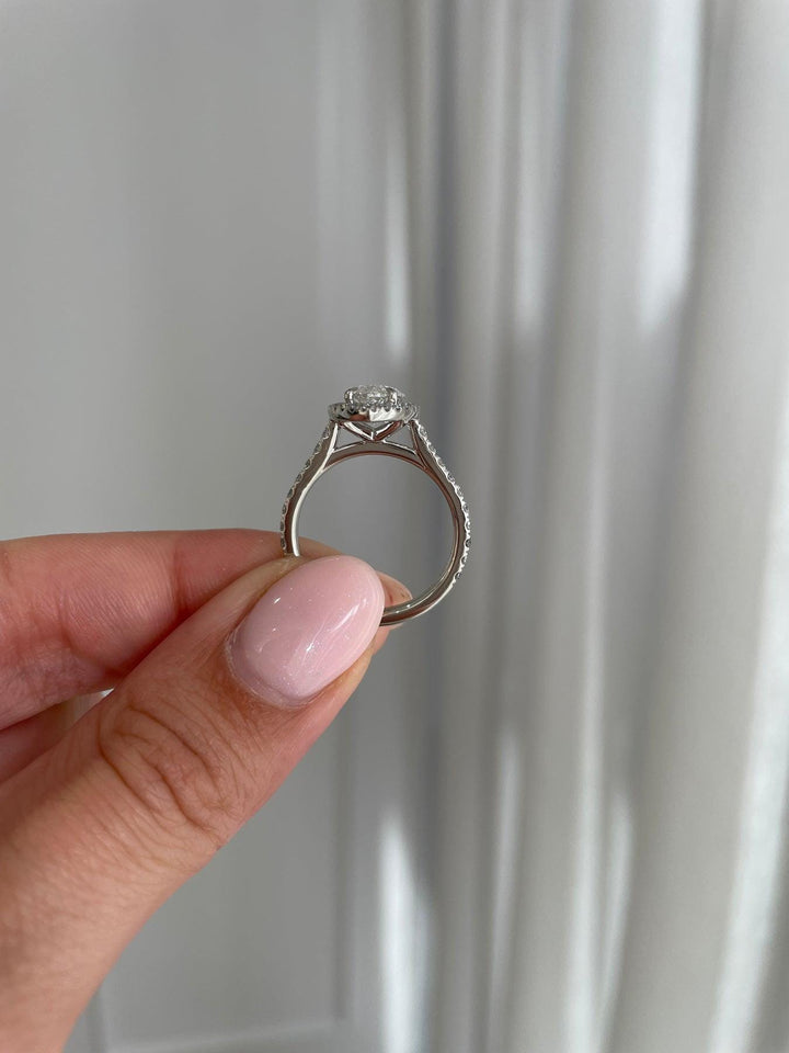 a woman's hand holding a diamond ring