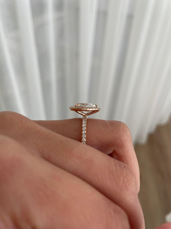 a close up of a person's hand holding a diamond ring