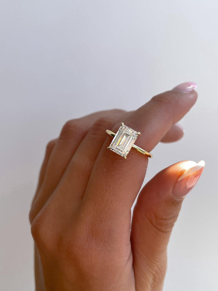 a woman's hand holding a diamond ring