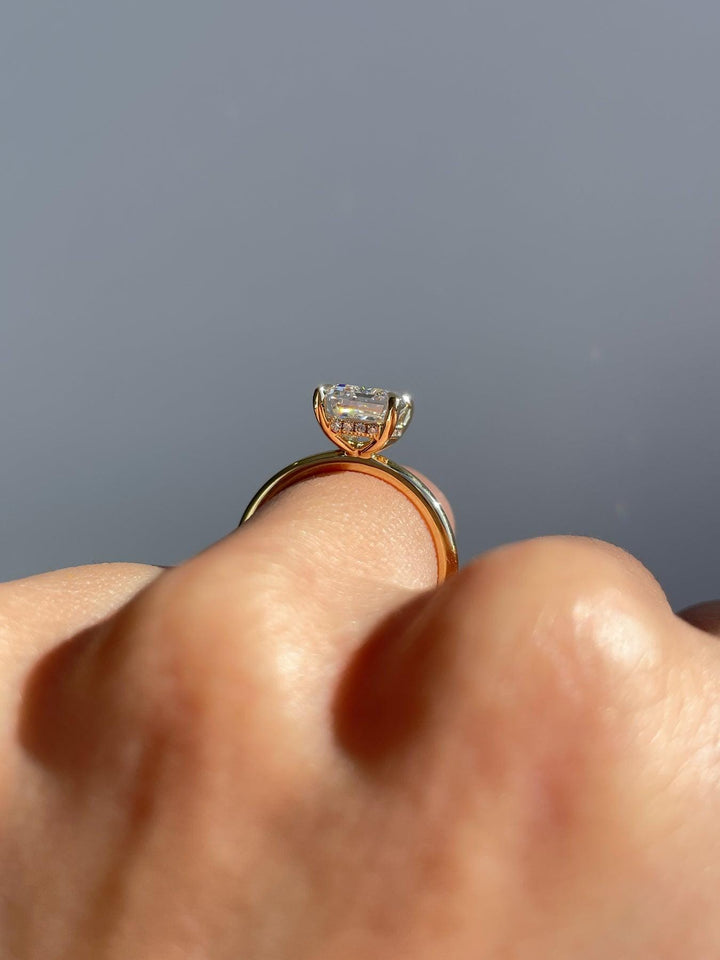a close up of a person's hand holding a diamond ring