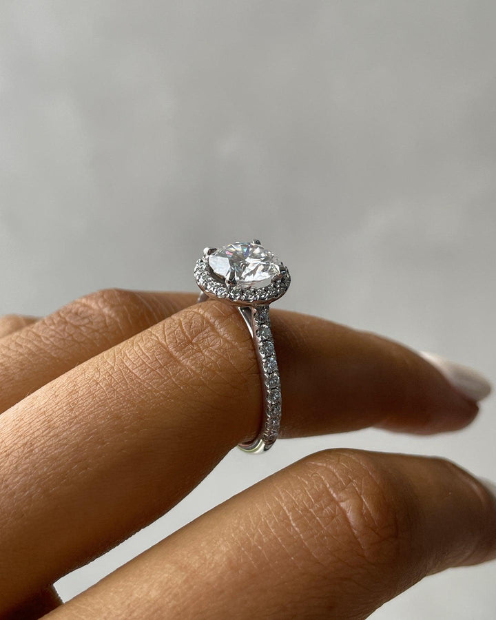 a close up of a person's hand with a diamond ring