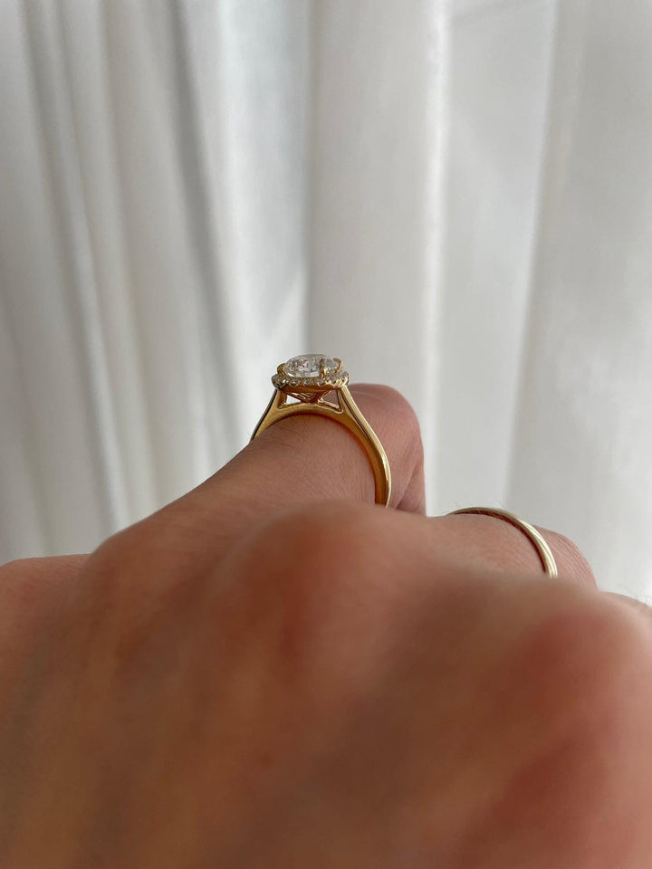 a person's hand holding a ring with a diamond on it