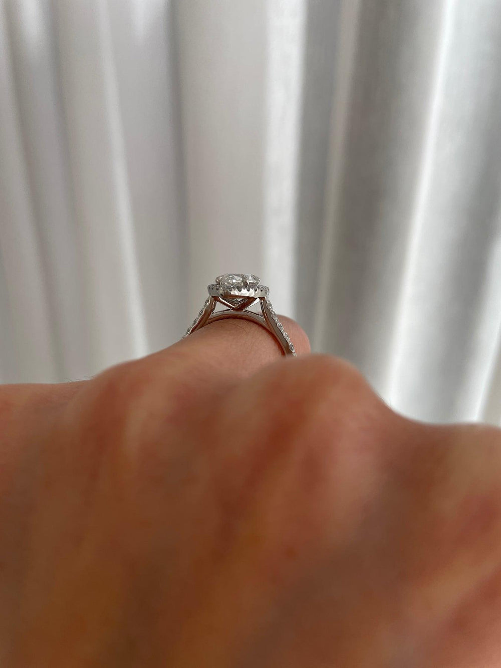 a close up of a person's hand holding a diamond ring