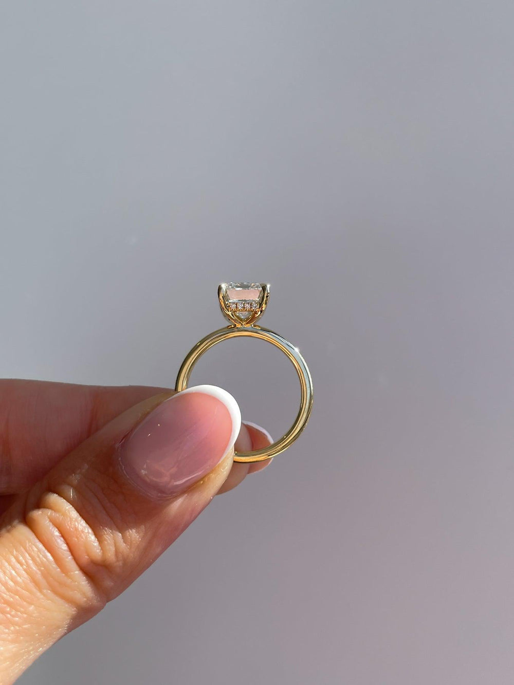 a woman's hand holding a ring with a diamond on it