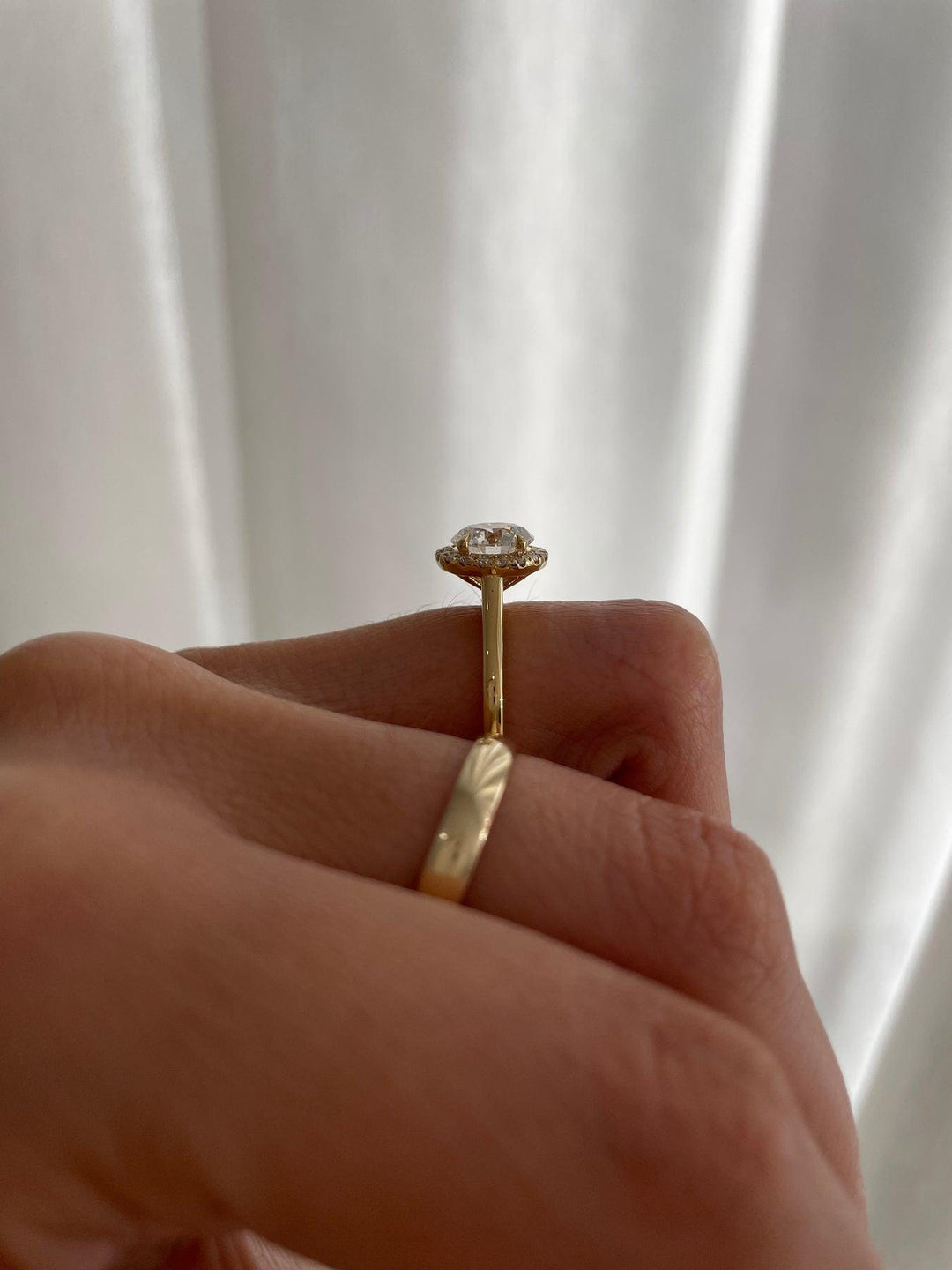 a woman's hand holding a diamond ring