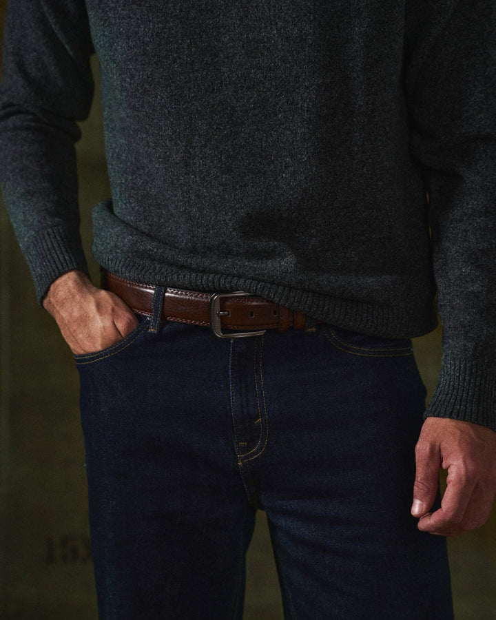 Brunt læderbælte til herre båret med mørke jeans og grå striktrøje