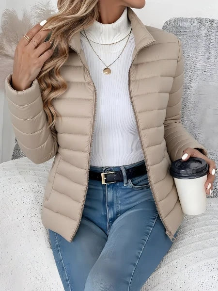 Beige let quiltet jakke dame stylet med jeans og hvid rullekravetrøje