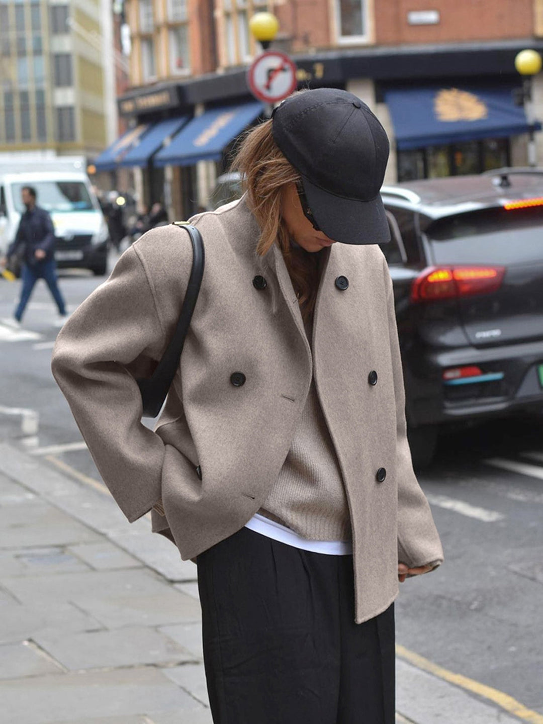 Oversized kort jakke dame stylet med sort kasket og sorte bukser