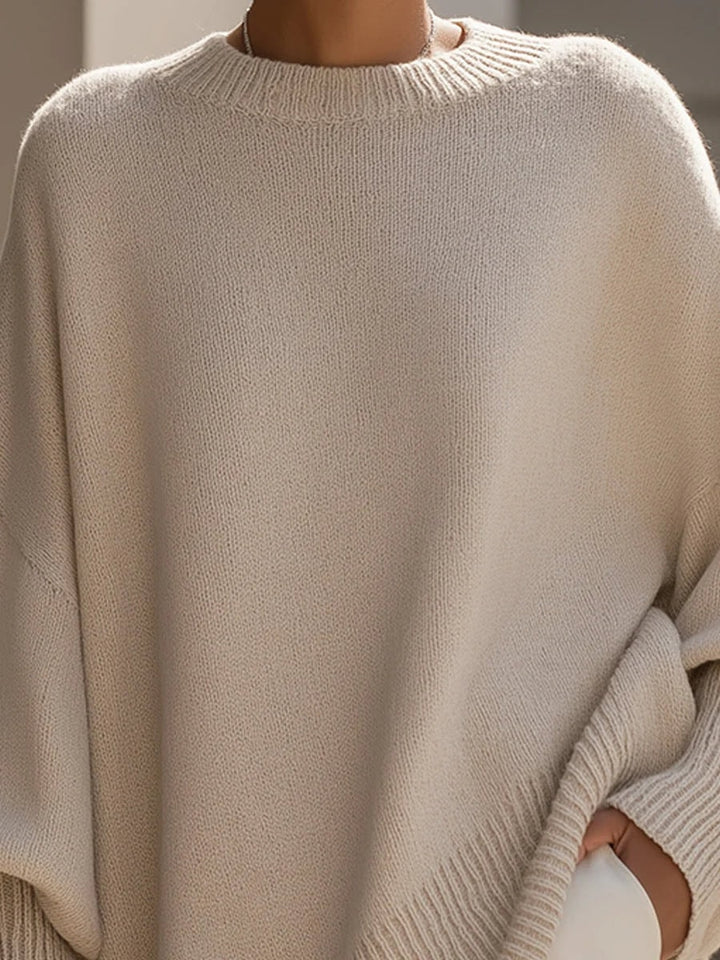 Nærbillede af beige strikbluse med rund hals og ribkant