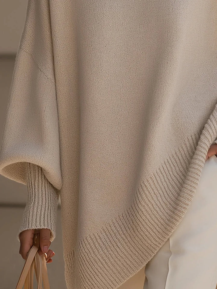 Detalje af ribstrikket manchet og asymmetrisk bundkant på strikbluse