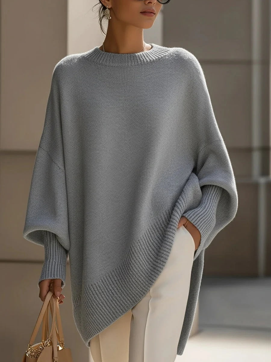 Oversized strikbluse dame med flagermusærmer og asymmetrisk kant