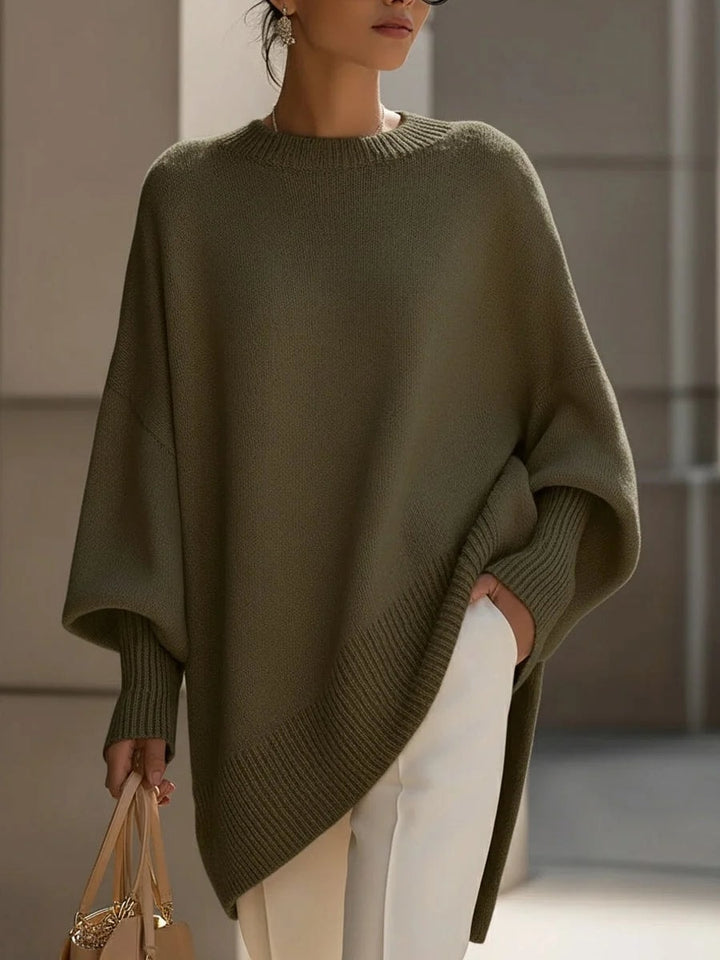 Oversized strikbluse dame med flagermusærmer og asymmetrisk kant