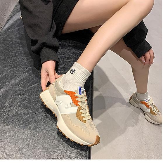 Sneakers dame i beige med orange detaljer båret med hvide sokker