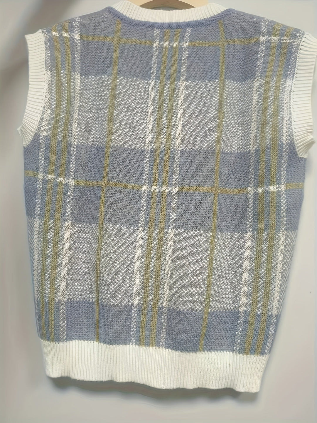 Bagsiden af ternet strikket vest i blå, grå og beige