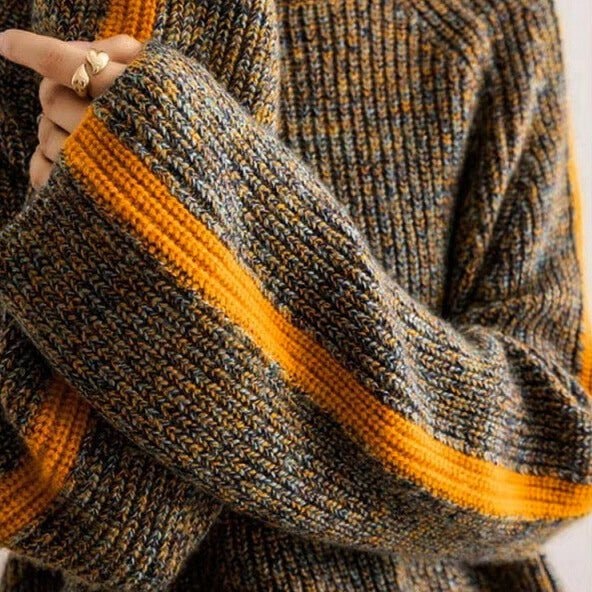 Nærbillede af ærme med orange stribe på melange striktrøje