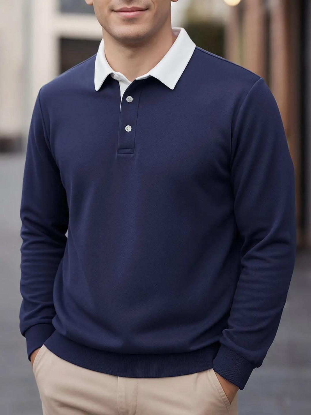 Mand iført marineblå langærmet polo sweatshirt med chinos
