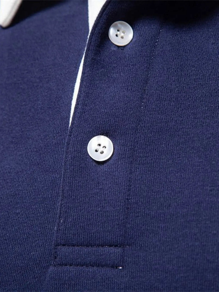 Nærbillede af knapper og polokrave på marineblå sweatshirt herre