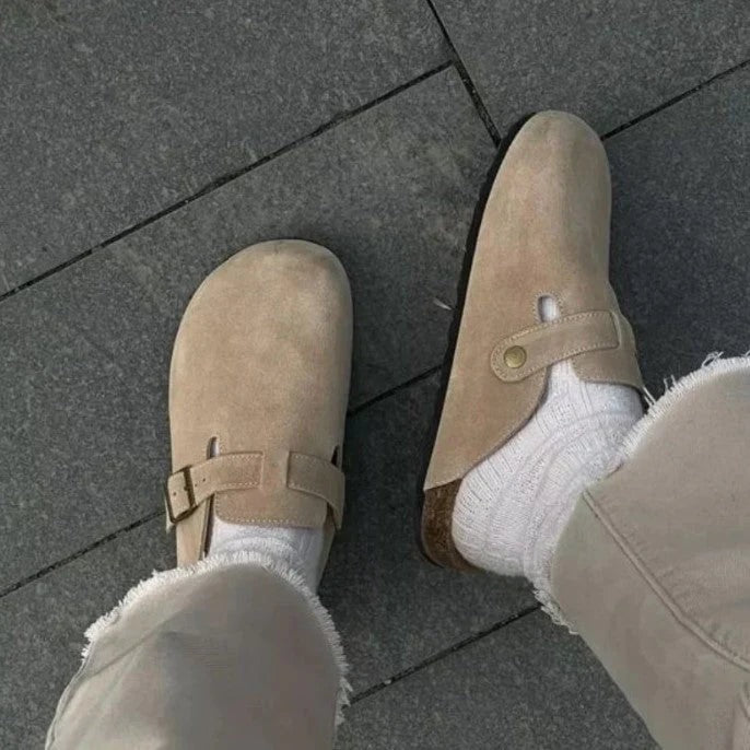 Beige slip-on træsko set oppefra med knap og spænde